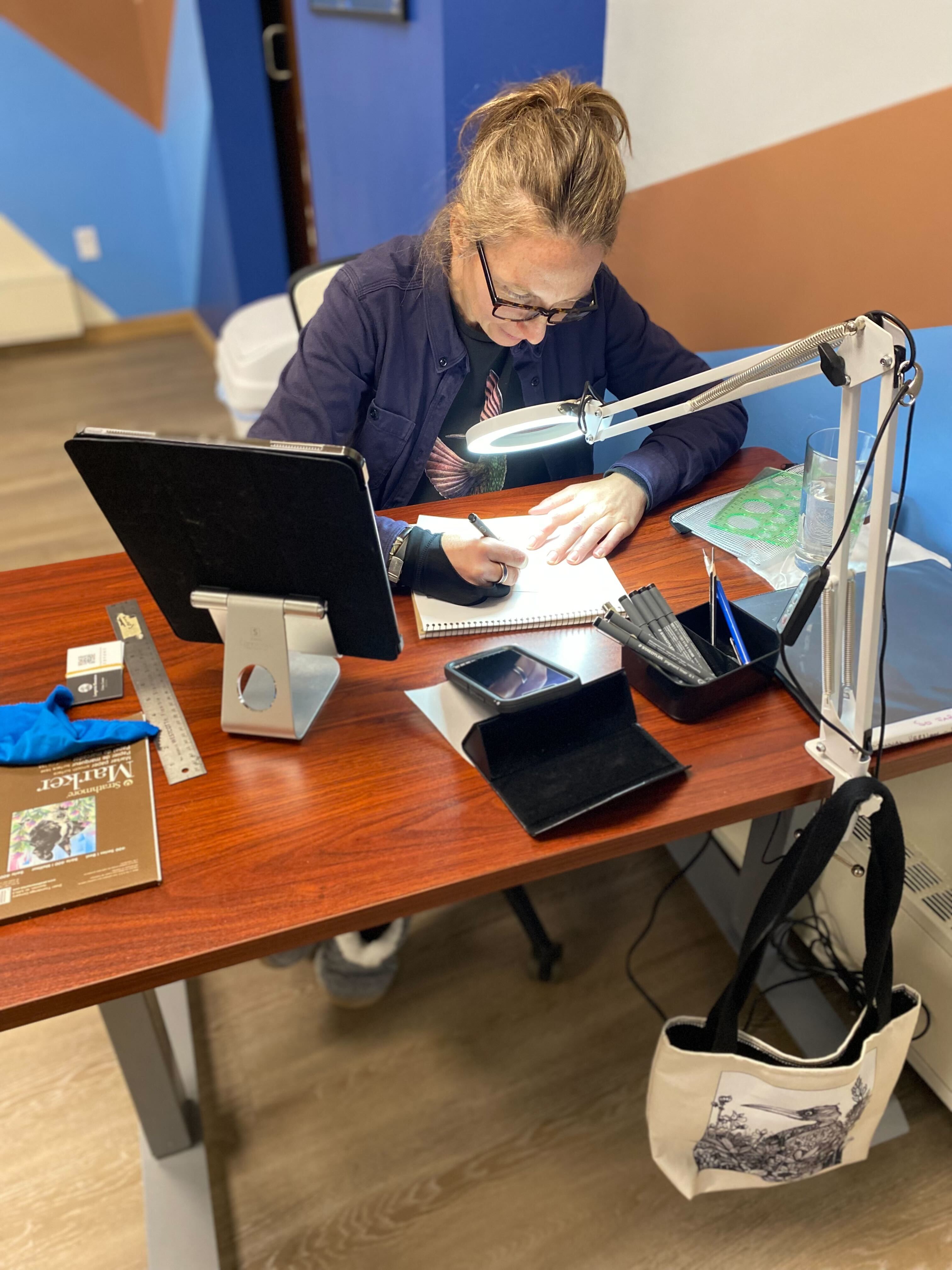 Chloe of Longstride Illustrations working diligently at her desk