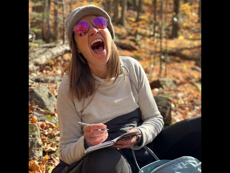 Guest laughs while sketching on a hike